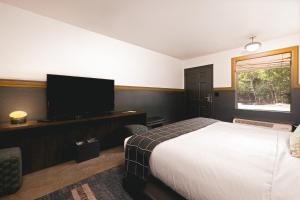 een slaapkamer met een bed en een flatscreen-tv bij The Ozarker Lodge in Branson