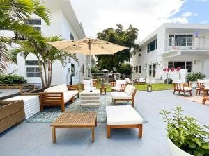 a patio with chairs and tables and an umbrella at Aqua Hotel in Fort Lauderdale