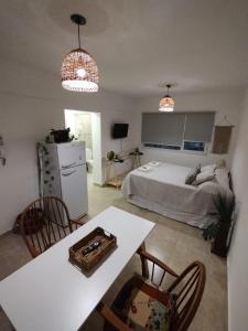 a bedroom with a bed and a table and chairs at La Félicité Alojamiento in Puerto Madryn +6 photos