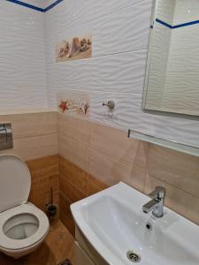 a bathroom with a white toilet and a sink at Цар Калоян in Primorsko