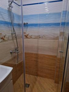 a shower with a painting of the beach at Цар Калоян in Primorsko