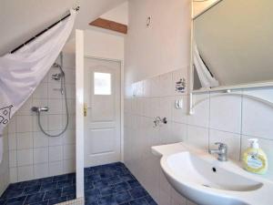 a bathroom with a sink and a shower with a mirror at 2-osobowy pokój na poddaszu z łazienką i dostępem do aneksu kuchennego in Wisełka