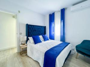 1 dormitorio con 1 cama azul y 1 silla azul en OleHolidays Cancelas centro ciudad, en Marbella