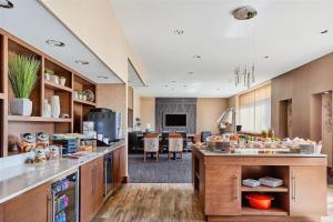a kitchen with wooden cabinets and a living room at Pittsburgh Marriott North in Cranberry Township