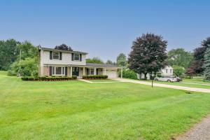 a house with a green lawn in front of it at Luxurious Bloomfield Hills Oasis with Pool and Spa! in Bloomfield Hills