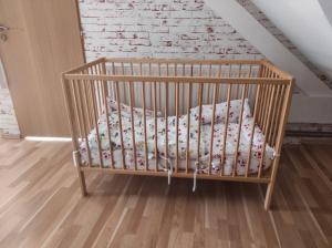 łóżeczko dziecięce z poduszką w pokoju w obiekcie Apartmány Greg w Czeskich Budziejowicach