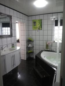 a bathroom with a tub and a sink at FeWo Blaue Oase, Netflix, Massagesessel, Whirlpool Badewanne in Germersheim