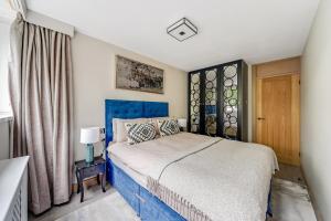 Un dormitorio con una cama azul y una ventana en My Oasis en Londres