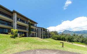 um edifício com uma colina relvada em frente em Hanalei Bay Resort em Princeville