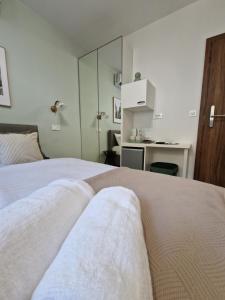 a bedroom with a bed with white sheets and a mirror at Verena's Place Old Town in Zadar