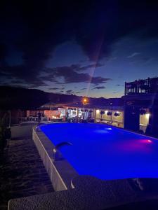 a large blue swimming pool on a rooftop at night at Guesthouse Viktoria Pensiune in Praid