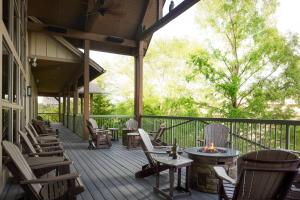 een veranda met stoelen en tafels en een vuurplaats bij Marriott's Willow Ridge Lodge in Branson