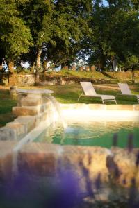 a swimming pool with a fountain in a park at Maison Lou Piade in Sarlat-la-Canéda