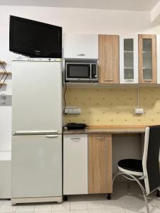 a kitchen with a refrigerator and a desk with a microwave at Best aparts in Leskovac