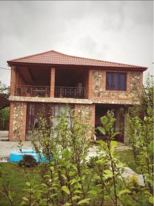 uma casa de tijolos com uma varanda em cima em Riverside Tekhuri em Martvili
