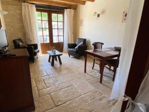 una sala de estar con una mesa y sillas en DomaineRossignol Lavande, en Gourdon-en-quercy