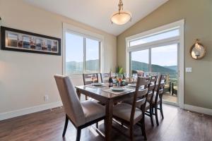 a dining room with a wooden table and chairs at Stunning 5 bed house on Silver Star mountain in Vernon