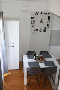 Apartman Cinkopan Premantura 1 في بريمونتيرا: غرفة طعام مع طاولة وكراسي وساعة على الحائط