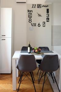 a dining room table with two chairs and a clock at Apartman Cinkopan Premantura 1 in Premantura