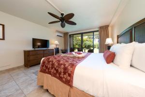 1 dormitorio con 1 cama grande y ventilador de techo en Hanalei Bay Resort en Princeville