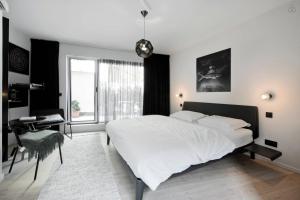 una camera da letto con un letto, una scrivania e una finestra di B&B Lucy in the Sky ad Anversa