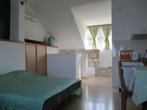 a kitchen with a bed in the middle of a room at Apartments Acalinović in Vis