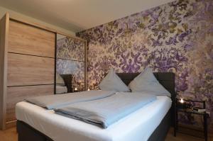 1 dormitorio con 1 cama con pared morada en Lechbruck am See - DAS STEINHÄUBL en Lechbruck