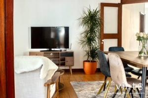 a living room with a dining table and a television at Apartamento do Arquinho II- by VinteOito in Amarante