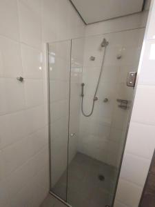 um banheiro com chuveiro e porta de vidro em Saint Lawrence Flat - 101 em São Paulo mais 30 fotografias