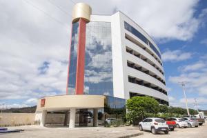 Un edificio alto con coches aparcados delante. en Nobile Hotel Araripina, en Araripina
