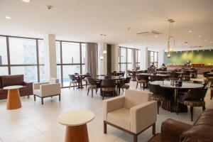 um restaurante com mesas, cadeiras e janelas em Nobile Hotel Araripina em Araripina