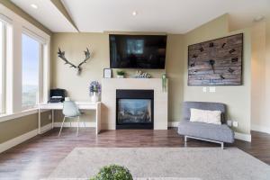 a living room with a fireplace and a tv at Stunning 5 bed house on Silver Star mountain in Vernon