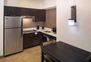 a kitchen with a refrigerator and a table in it at Residence Inn Columbia Northeast/Fort Jackson Area in Columbia