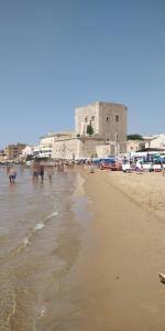 a view of a beach with a building in the background at Luan's House in Pozzallo