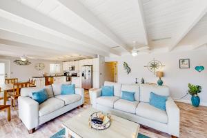 a living room with two white couches and a table at Breezy Keys in Key Colony Beach