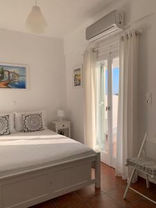 Habitación blanca con cama y ventana en Sea and Salt Naxos 1, en Kastraki Naxou