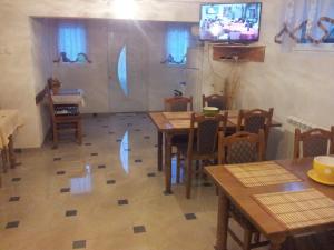 a dining room with tables and chairs and a tv at Guest House Family Varda Plitvice Lakes in Plitvička Jezera
