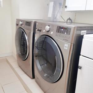two washing machines sitting next to each other in a kitchen at A bright and tidy room in midtown near subway in Toronto