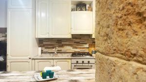 a kitchen with white cabinets and a stove top oven at via ROMA 100 ROOMS in Enna