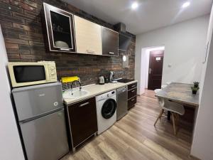 a small kitchen with a sink and a microwave at ApartmentsByMatyrafa-III in Tarnowskie Góry