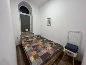 a small bedroom with a bed and a chair at ApartmentsByMatyrafa-III in Tarnowskie Góry