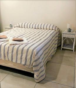 un letto con una coperta a righe e due tavoli di Departamento Olympia Village - Mendoza a Mendoza