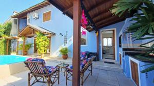 佛羅安那波里的住宿－Nuna Hostel Floripa，一个带椅子的庭院、一个游泳池和一个房子