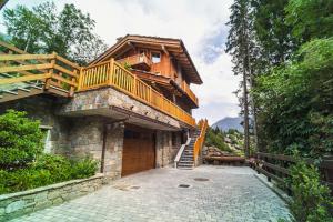 a house with a balcony on top of it at Suites Courmayeur - Mont Blanc in Courmayeur