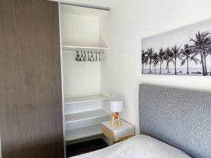 a bedroom with a bed and a lamp and palm trees at Departamentos Premium - Boero Rentals in Belén de Escobar