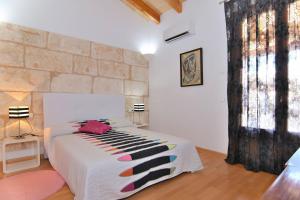 a bedroom with a bed with a stone wall at 265 Es Colomer ETV11174 by Mallorca Charme in Muro +36 photos