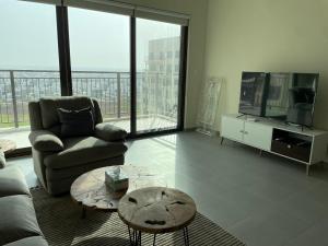 ein Wohnzimmer mit einem Sofa und einem Tisch in der Unterkunft Emaar South - Two Bedroom Apartment with Pool and Golf Course View in Dubai