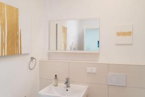 een witte badkamer met een wastafel en een spiegel bij Penthouse Nähe Frankfurt am Main in Hanau am Main