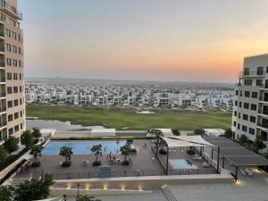 an aerial view of a city with buildings at Emaar South - Two Bedroom Apartment with Pool and Golf Course View in Dubai
