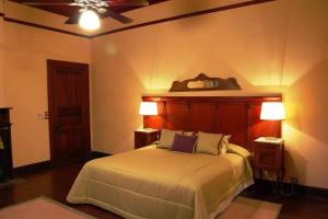 a bedroom with a bed with two lamps and a ceiling at Casco histórico de Estancia in Monte Buey